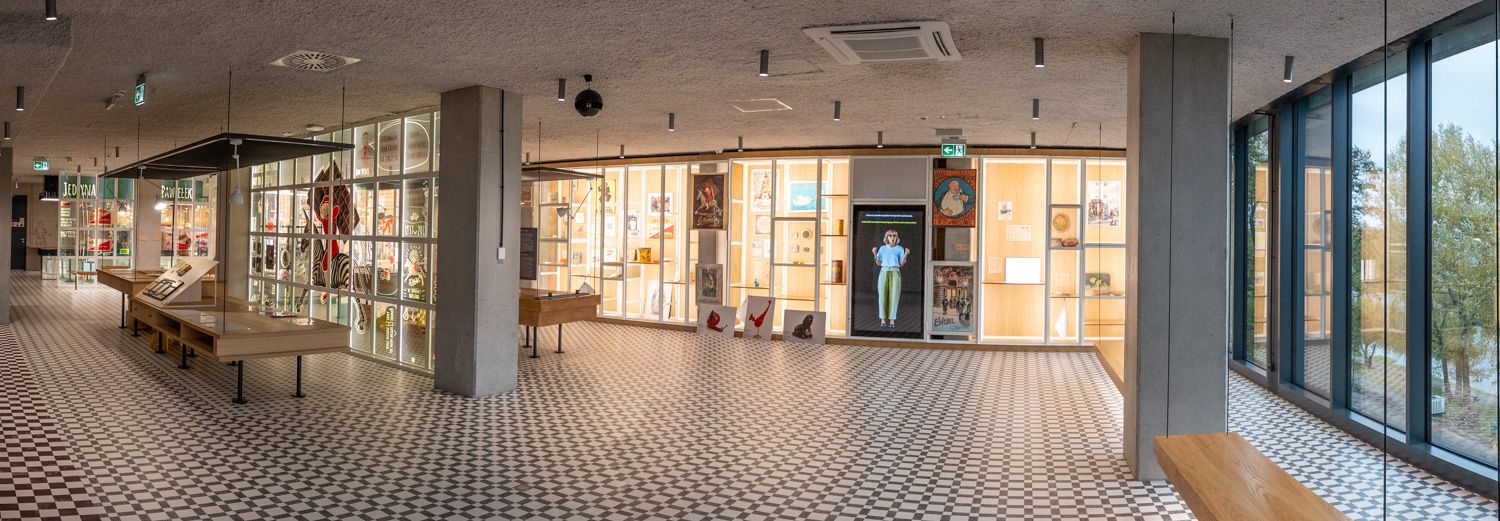 sala projektantki z ekranem przedstawiającym wirtualnego przewodnika i ścianę z ekspozycją historycznych opakowań